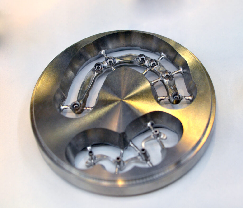 Disc CAD CAM dental machinery for milling prosthesis and crowns with a cut out bridge for implants close-up